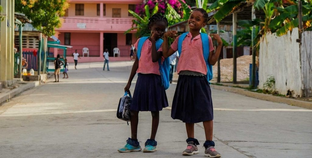 Two schoolgirls laughing in Corail, Haiti