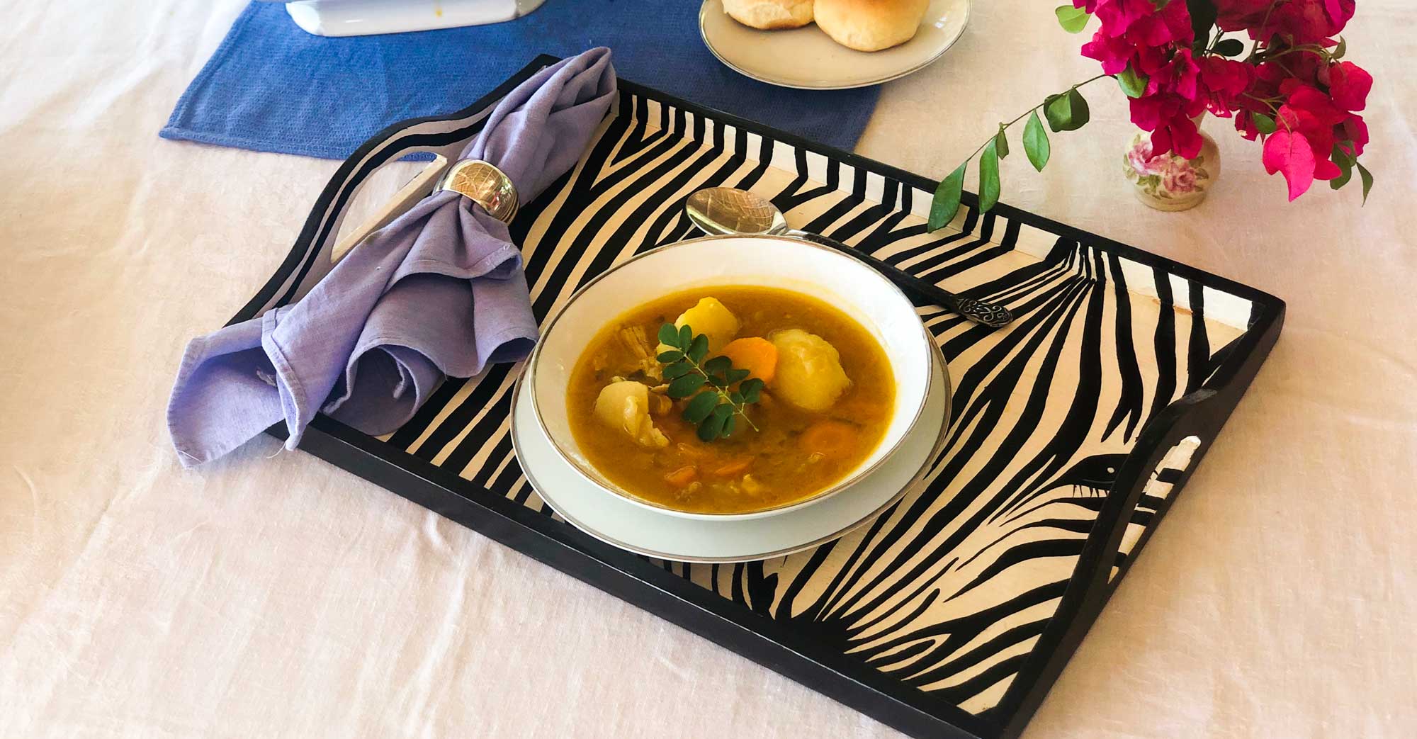 A bowl of soup joumou on a serving tray