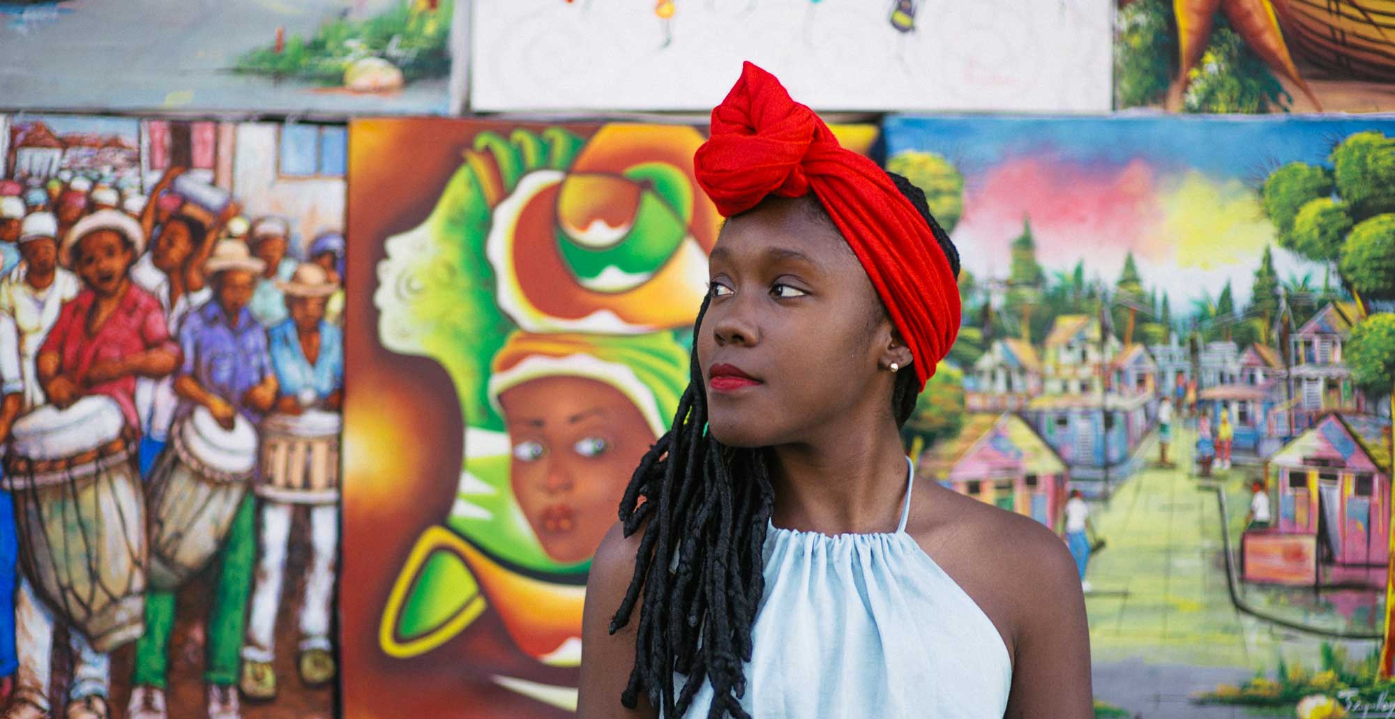 portrait d'une jeune fille haïtienne stylée, avec de longues dreadlocks et un foulard rouge