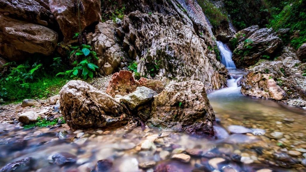 Waterfall plunges into a stony pool at Kaskad Boukan