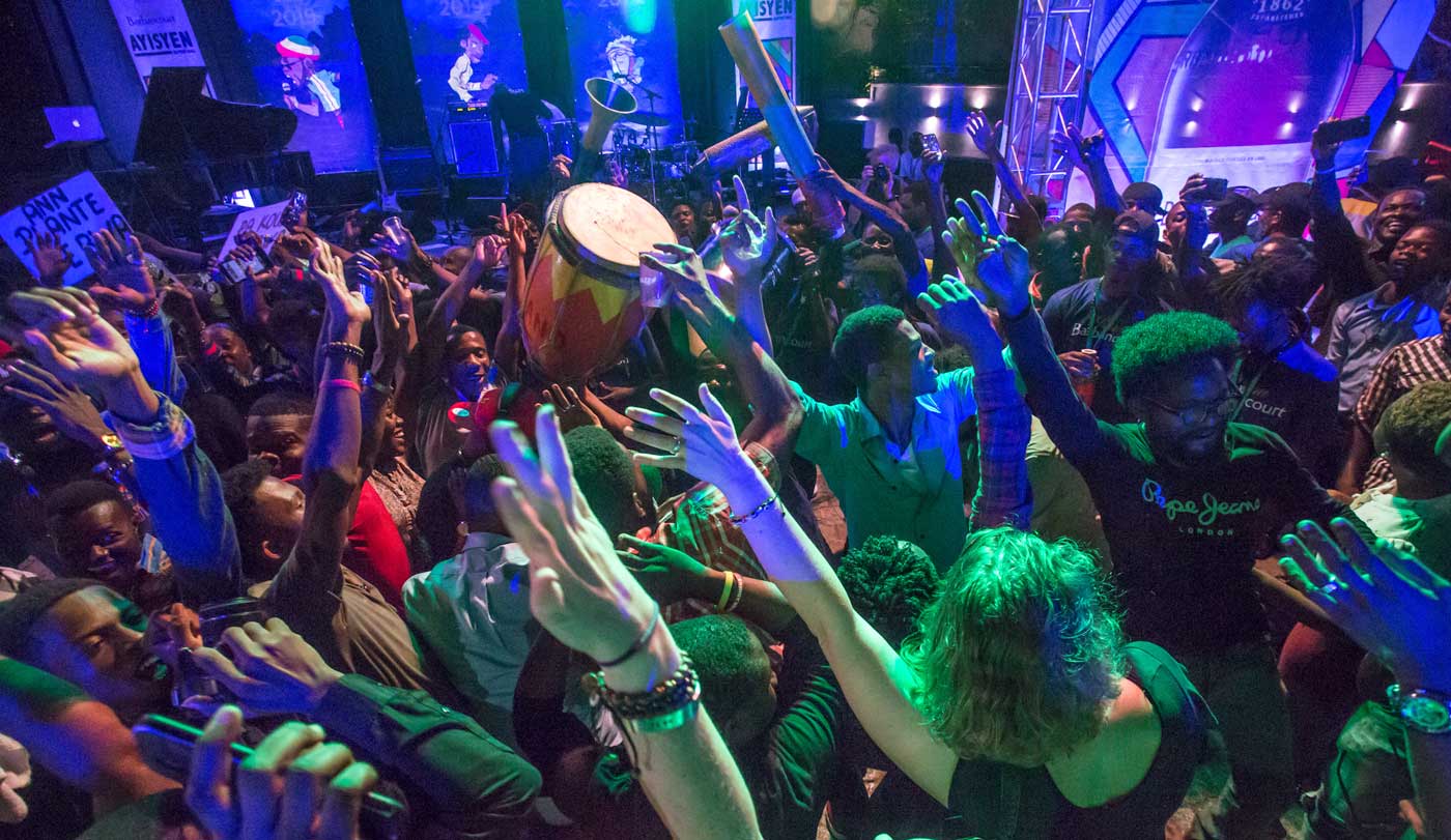 crowd of people dancing with hands in the air during a concert