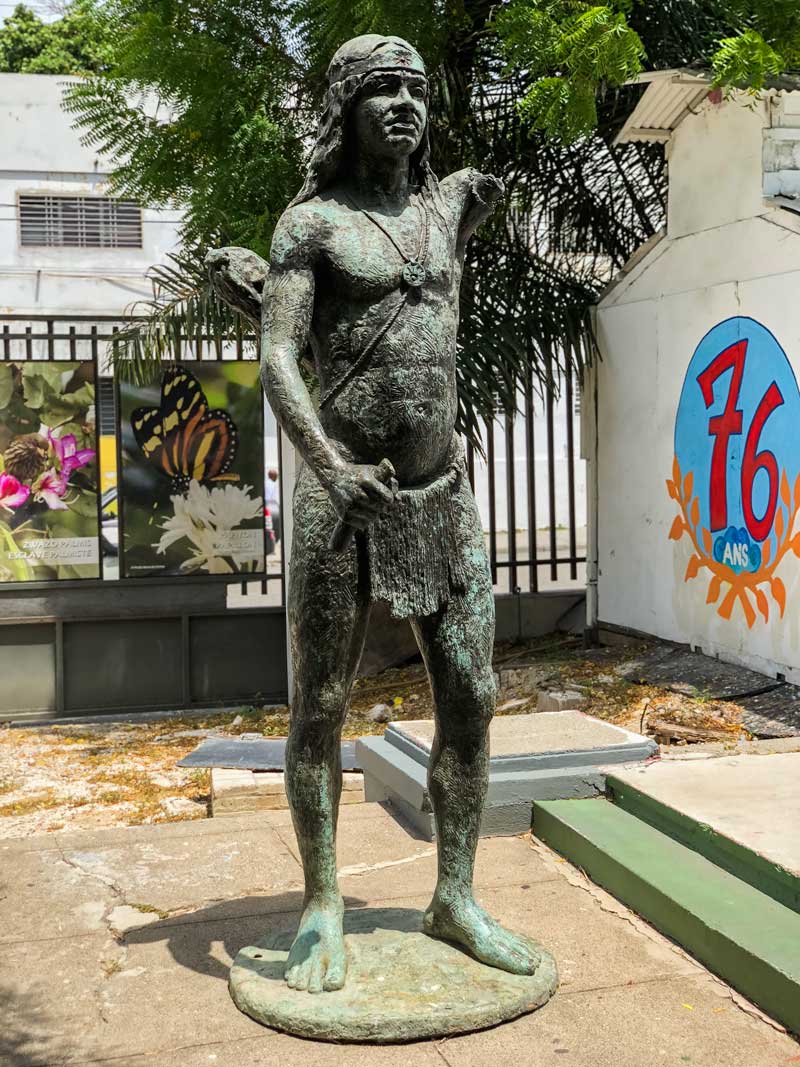 bronze statue of taino indian in museum courtyard