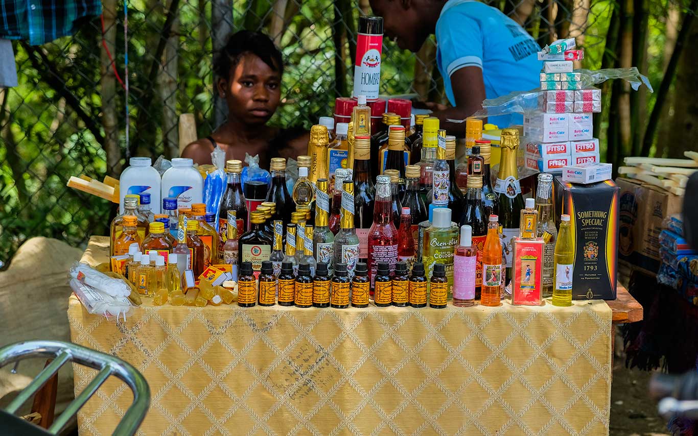 haitian girl sitting behind table with merchandise for sale