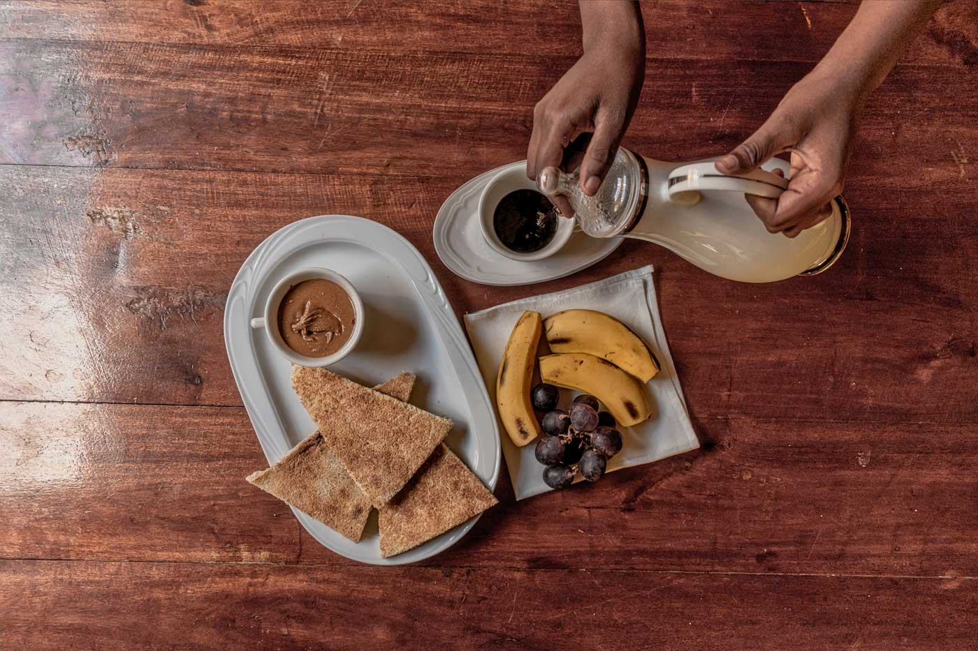 table with haitian coffee, cassava, fruits and peanut butter