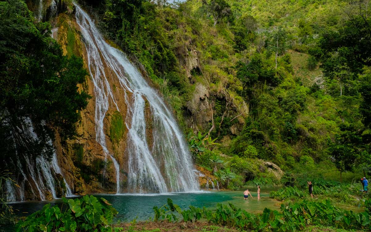 tall waterfall splashing down mountain side into natural pool