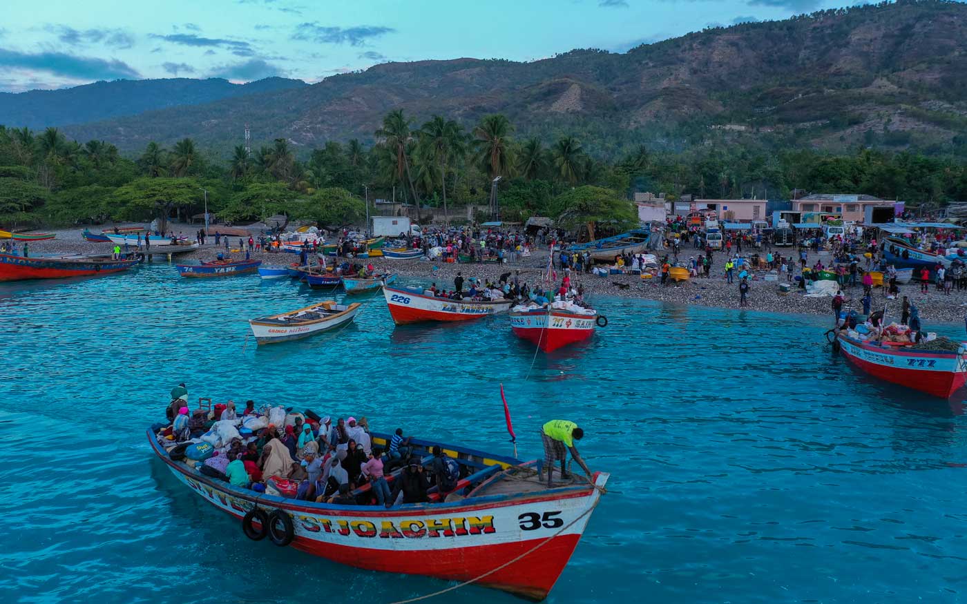 large wooden boats with haitians docking on beach