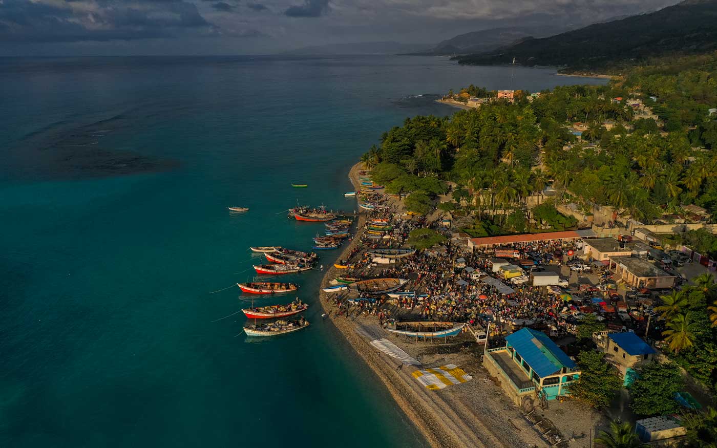 aerial view of coastal village with market area and boats