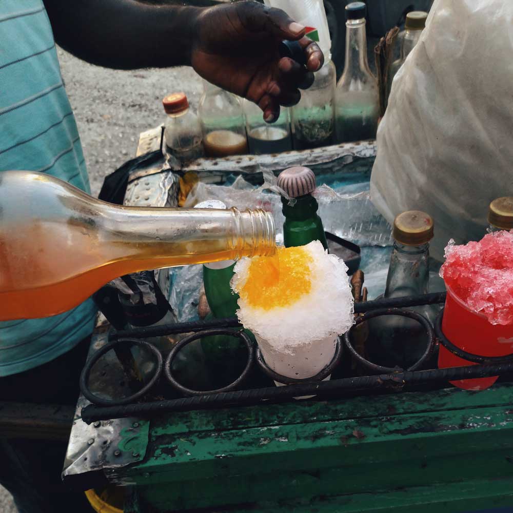 vendor pouring syrup on shaved ice