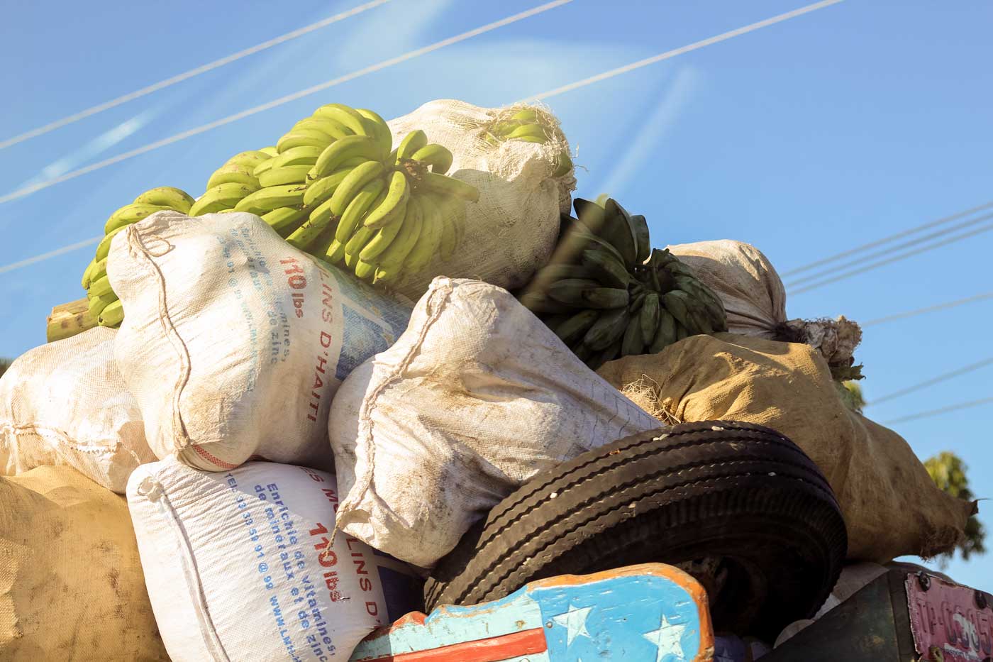 bags of haitian fruits and vegetables packed on top of bus