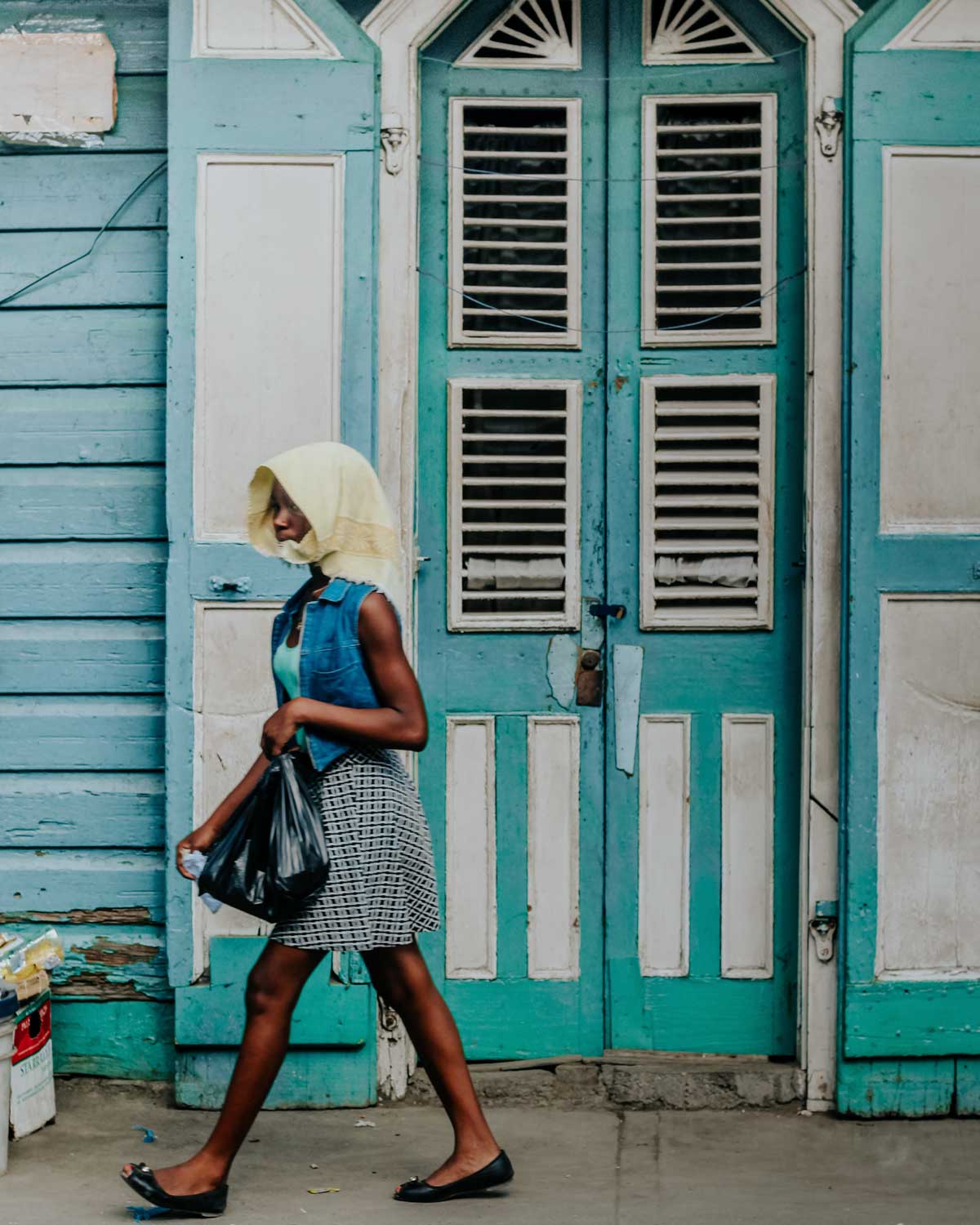 haitian girl walking in front of old colonial style house