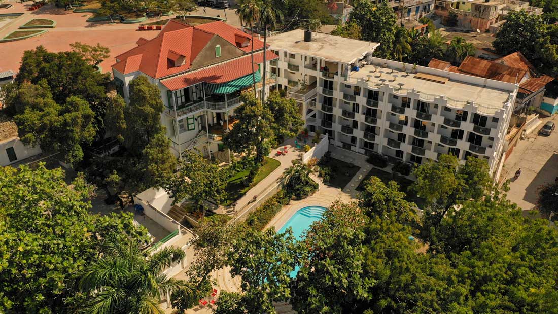 aerial view of hotel buildings with a large pool and garden area