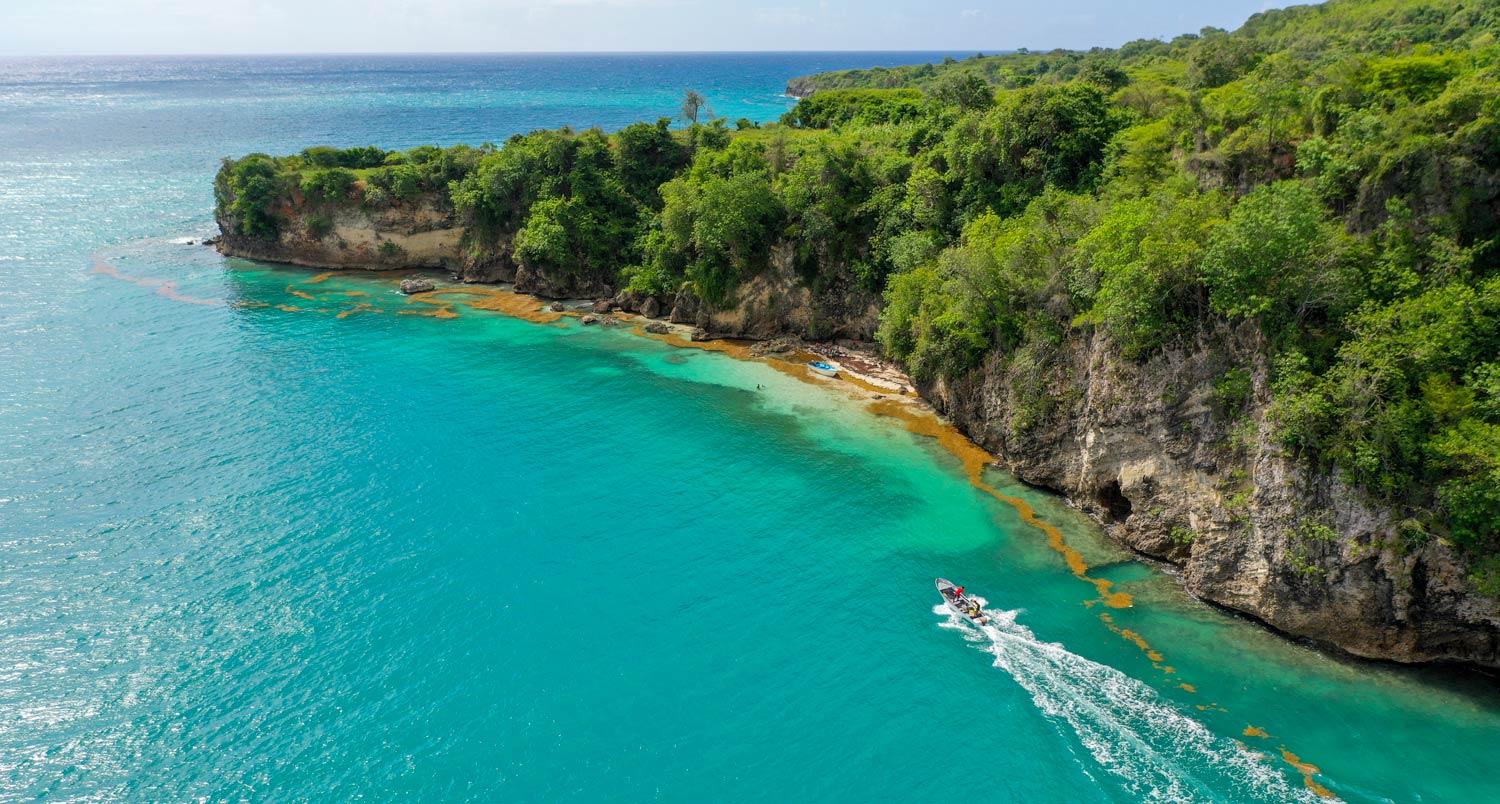 dramatic haitian coastline with jungle forest and speed boat