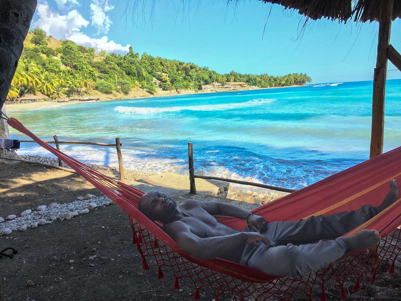 man laying in a hammock by the ocean