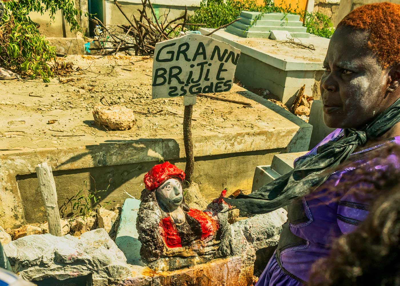 haitian vodou practitioner at cemetery wearing a black and purple dress