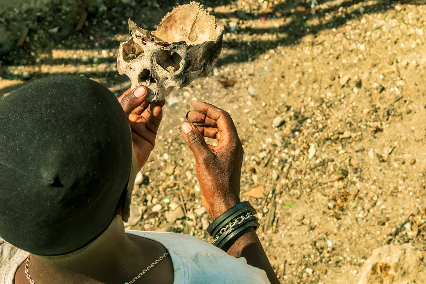 haitian man holding a part of a human skull for fet gede