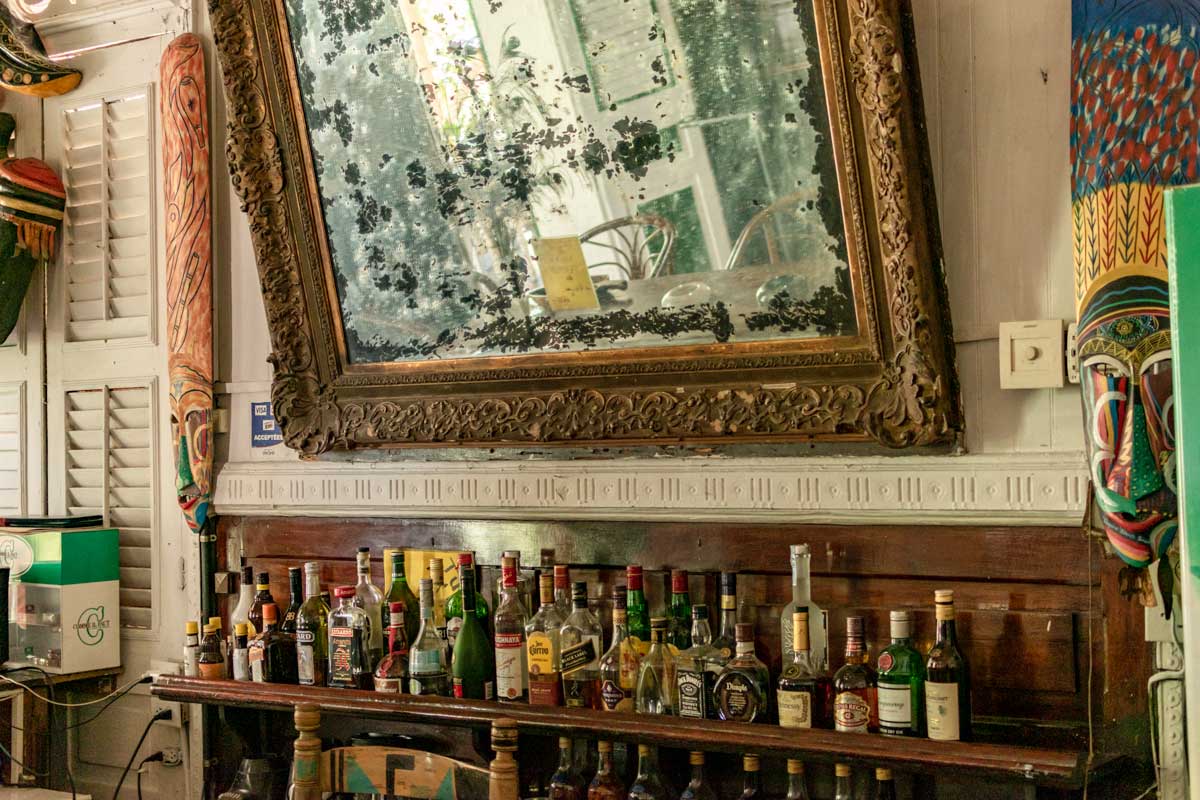 hotel bar interior with liquor bottles and old framed mirror
